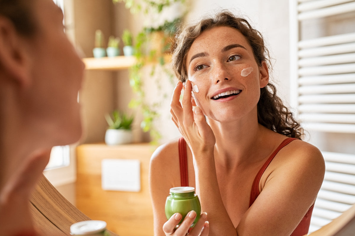 A woman applying moisturiser to her face as part of her morning routine