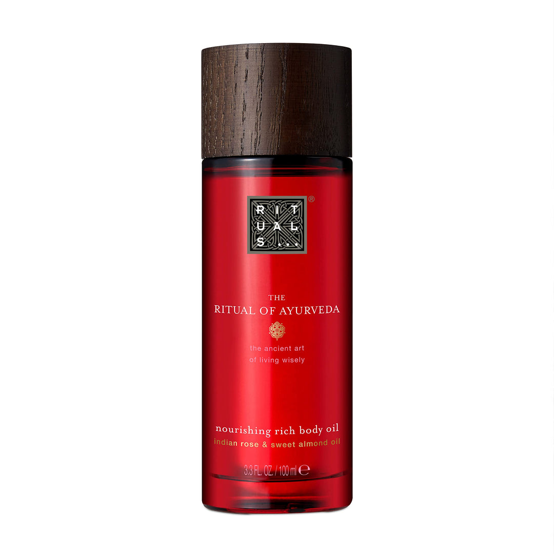 Glass bottle of golden Ayurvedic body oil with botanical oils, 100 ml