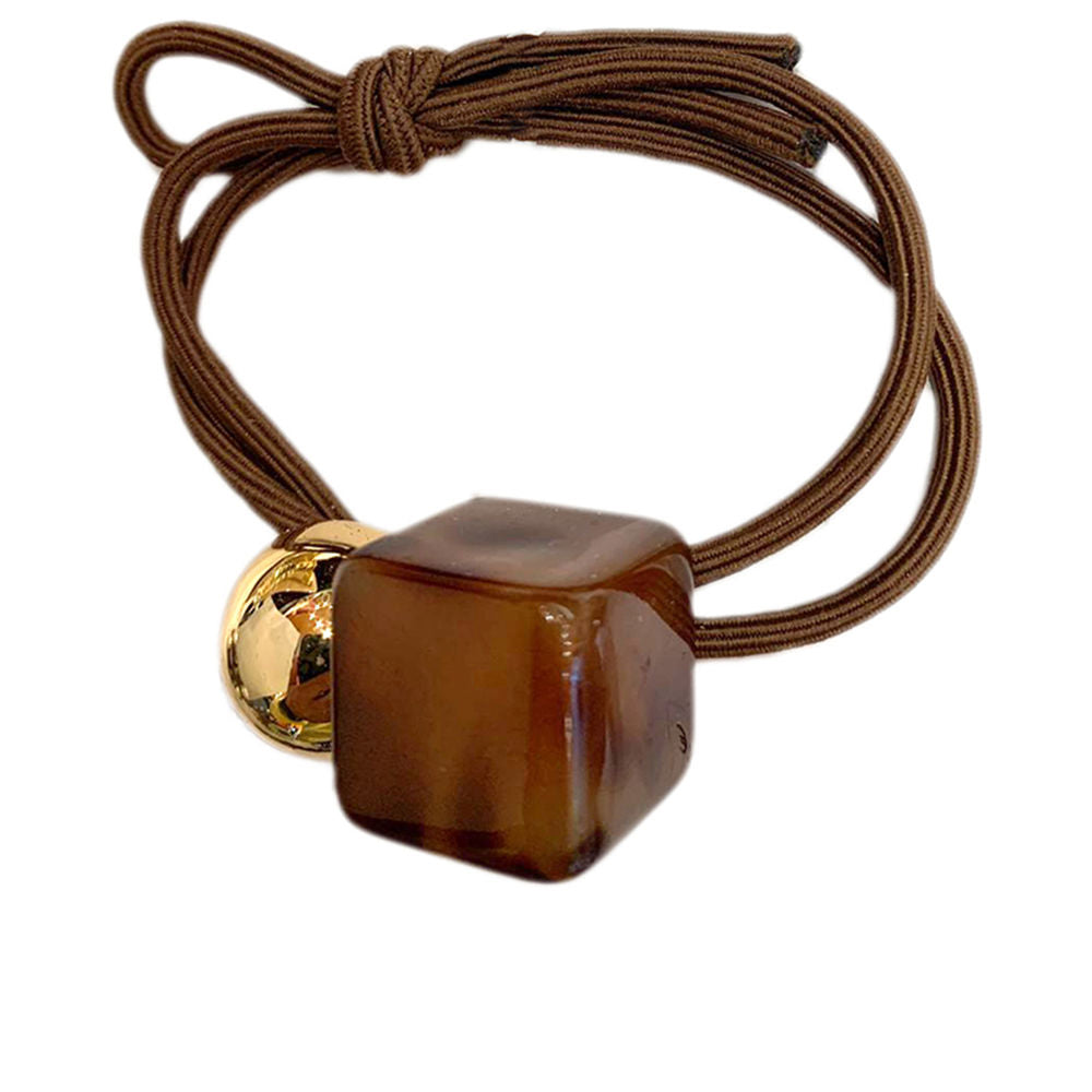 Brown elastic hair tie with square plastic bead, gold metal round bead, knotted elastic—Inca.