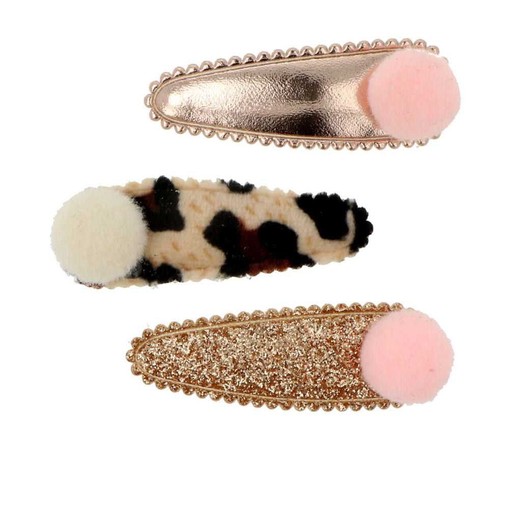 Three Inca baby hair clips topped with soft pom-poms, neutral tones