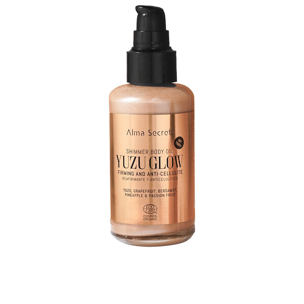 Alma Secret Rose-gold plastic body oil bottle with pump dispenser, shimmering liquid, metallic label, printed text, modern sleek design
