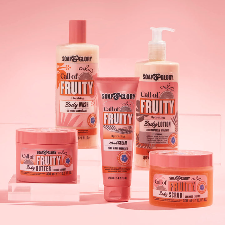 Soap &amp; Glory Plastic cylindrical body wash bottle in pink, orange and beige with flip-top cap, fruit and floral graphics, bold text branding, measurement markings — .