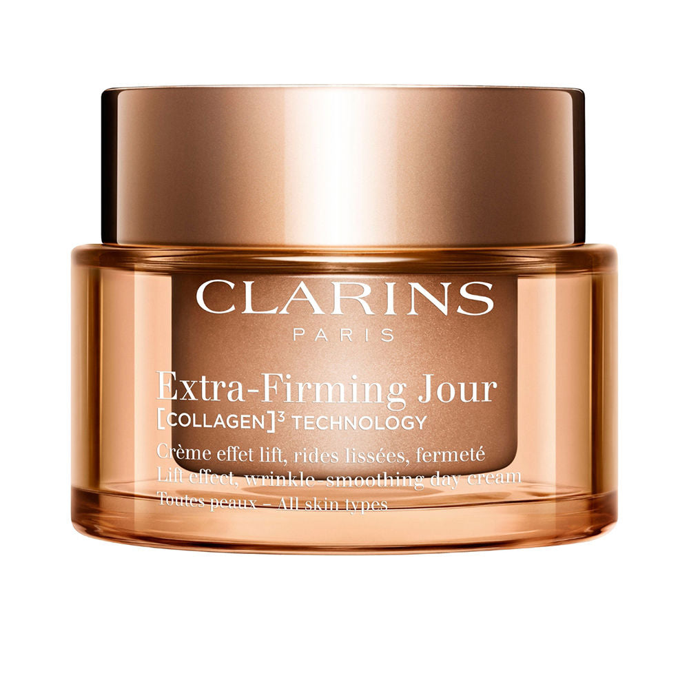 Bronze cylindrical plastic face cream jar with metallic lid, transparent sides and white text, Clarins